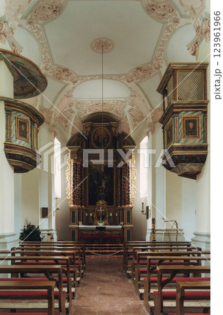 Scenic view of a charming lakeside village featuring a historic church, surrounded by majestic mountains. Tourists enjoy the tranquil atmosphere and beautiful architecture in Konigsse lake Bavaria 123961966