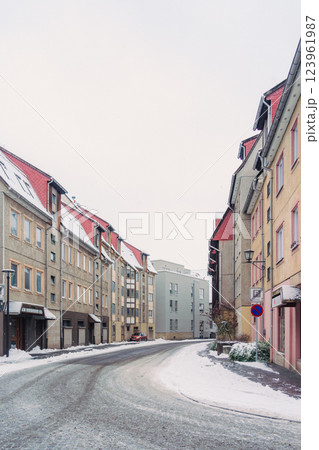 A picturesque snowy road gracefully winding through a charming little village during the magical winter season 123961987