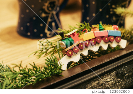 A charming wooden toy train set against a festive backdrop filled with various greenery, perfect for holiday decor A charming wooden toy train set against a festive backdrop filled with various greenery, perfect for holiday decor 123962000