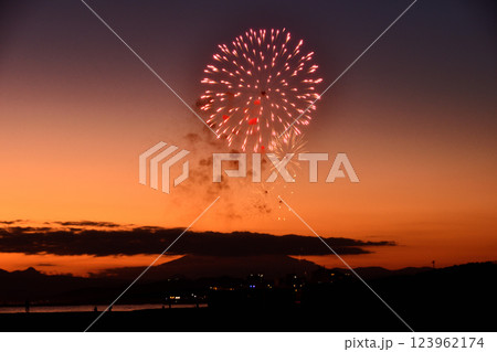 夕焼けの富士山のシルエットをバックに打ち上げられる花火 123962174