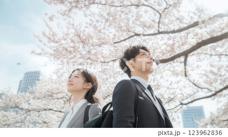 春、希望を胸に空を見つめる新社会人と満開の桜 123962836