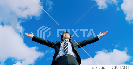 自由と挑戦、青空に手を伸ばす若手ビジネスマン 123962891