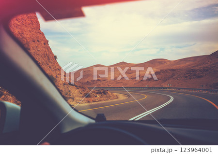 Driving a car on a mountain road in the desert. View of the sandstone mountains through the windshield. Israel 123964001