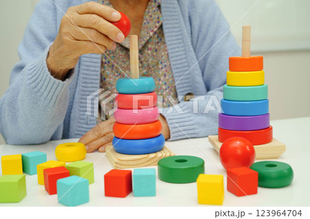 Asian elderly woman playing enhancing skill board game. 123964704
