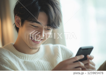 スマホを操作する若いアジア人男性「AI生成画像」 123965478