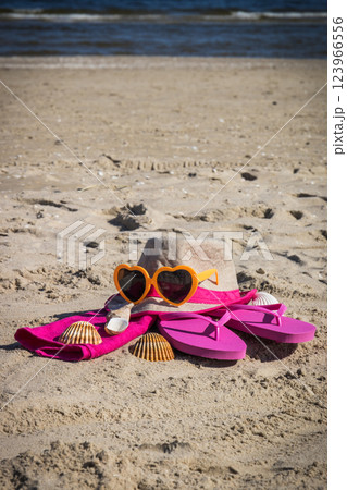 Accessories for relax on beach. Straw hat, flip flop and towel. Summertime Accessories for relax on beach. Straw hat, flip flop and towel. Summertime 123966556