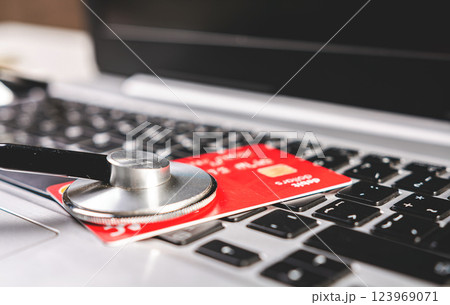 Stethoscope and credit card on the keyboard. Medical healthcare cost concept. Stethoscope and credit card on the keyboard. Medical healthcare cost concept. 123969071