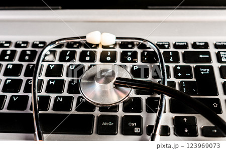 Stethoscope on laptop keyboard. Online medical consultation concept Stethoscope on laptop keyboard. Online medical consultation concept 123969073