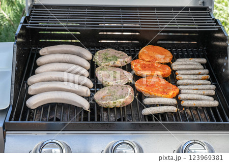 Barbecue grill bbq on propane gas grill steaks bratwurst sausages meat meal 123969381