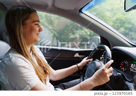 A young girl is driving a car. an inexperienced driver.  123970165