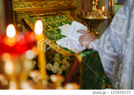 A priest with a prayer book on a table conducts the service. A priest with a prayer book on a table conducts the service. 123970177