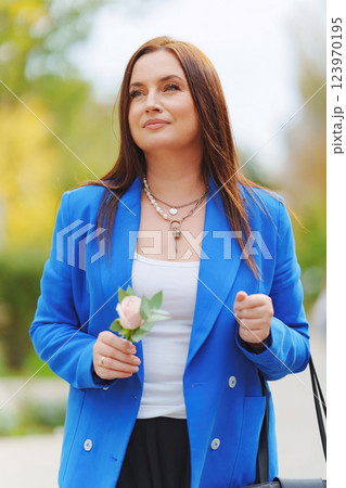 Attractive brunette woman in blue jacket with Rose Flower. Attractive brunette woman in blue jacket with Rose Flower. 123970195