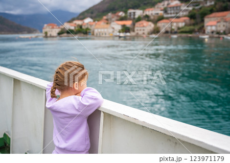 Little girl traveling with family by ferry. Crossing from one bank to another of Kotor bay in Montenegro 123971179