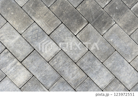 Gray concrete or stone pavers forming herringbone pattern 123972551