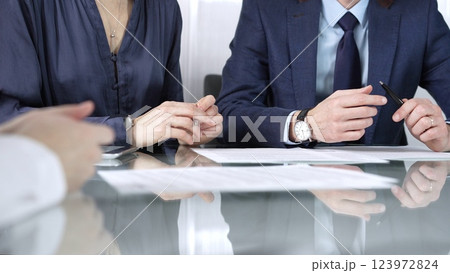Business partners or lawyers are reviewing contract terms during a meeting, negotiating and making decisions together. Business people concept, close up view Business partners or lawyers are reviewing contract terms during a meeting, negotiating and making decisions together. Business people concept, close up view 123972824