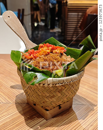 Traditional Nasi Bakul in Woven Basket - Authentic Indonesian Cuisine on Wooden Table 123973673