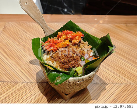 Traditional Nasi Bakul in Woven Basket - Authentic Indonesian Cuisine on Wooden Table 123973683