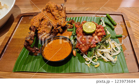Traditional Ayam Taliwang indonesian cuisine with Vegetable Mash and Curry Soup on Banana Leaf 123973684