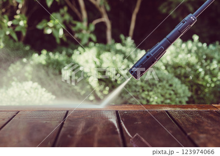 cleaning terrace with a power washer - high water pressure cleaner on wooden terrace surface 123974066