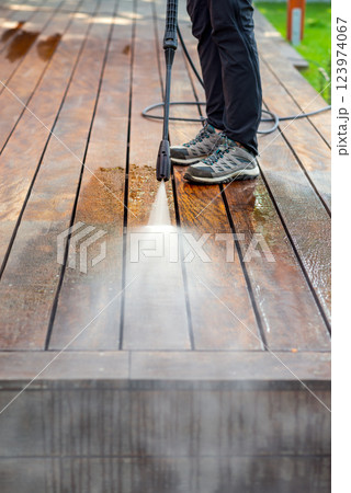 cleaning terrace with a power washer - high water pressure cleaner on wooden terrace surface cleaning terrace with a power washer - high water pressure cleaner on wooden terrace surface 123974067