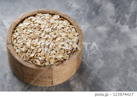 Wooden Bowl with Raw Oat Flakes On Textured Grey Background, Healthy Breakfast Ingredient, Copy Space Wooden Bowl with Raw Oat Flakes On Textured Grey Background, Healthy Breakfast Ingredient, Copy Space 123974427