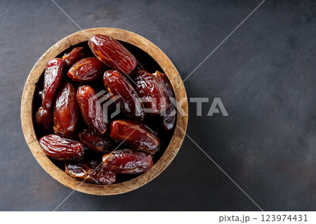Dried Dates in Wooden Bowl on Dark Background, Top View, Copy Space Dried Dates in Wooden Bowl on Dark Background, Top View, Copy Space 123974431
