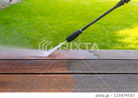 cleaning terrace with a power washer - high water pressure cleaner on wooden terrace surface 123974583