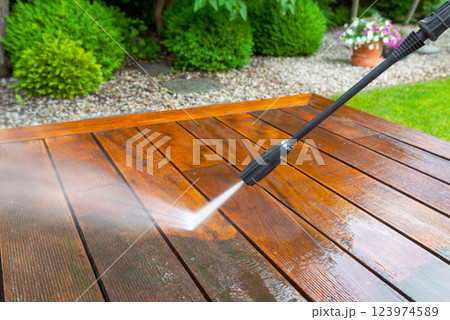 cleaning terrace with a power washer - high water pressure cleaner on wooden terrace surface cleaning terrace with a power washer - high water pressure cleaner on wooden terrace surface 123974589