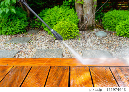 cleaning terrace with a power washer - high water pressure cleaner on wooden terrace surface cleaning terrace with a power washer - high water pressure cleaner on wooden terrace surface 123974648