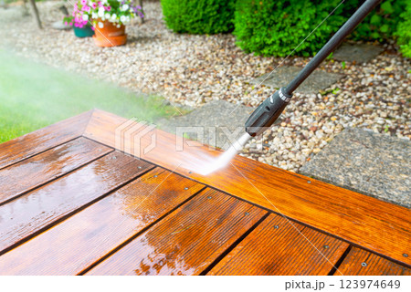 cleaning terrace with a power washer - high water pressure cleaner on wooden terrace surface cleaning terrace with a power washer - high water pressure cleaner on wooden terrace surface 123974649