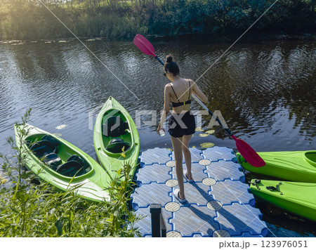 young skinny girl with an oar is about to board young skinny girl with an oar is about to board 123976051