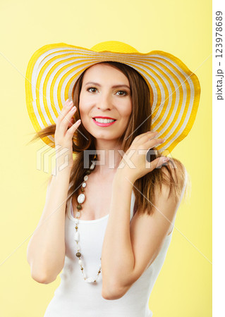 Woman in big yellow summer hat. 123978689