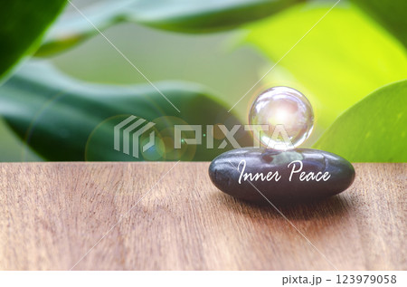Inner peace text on zen stone with bright shining glass marble. Inner strength concept 123979058