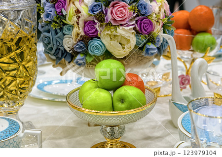 Fresh fruits in glass vase on festively decorated table. 123979104