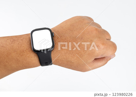 A chubby Asian man with yellow skin wearing a black smartwatch on his wrist with a white screen. 123980226