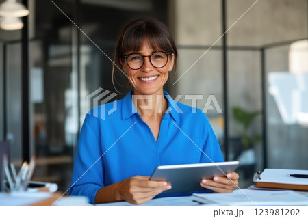 Modern Businesswoman Typing and Reading on Tablet Modern Businesswoman Typing and Reading on Tablet 123981202