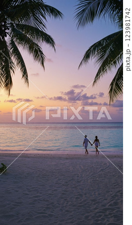 Romantic sunset walk on tropical beach with palm trees 123981742