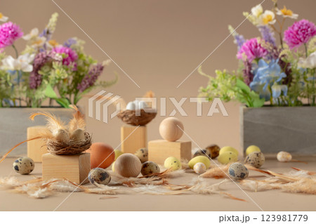 Easter composition with eggs, feathers, and spring flowers on a beige background. Easter composition with eggs, feathers, and spring flowers on a beige background. 123981779