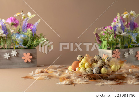 Easter composition with eggs, feathers, and spring flowers on a beige background. Easter composition with eggs, feathers, and spring flowers on a beige background. 123981780