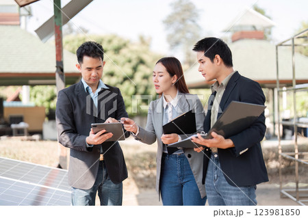 Sustainable business initiative. Professionals analyzing solar energy data outdoors. 123981850