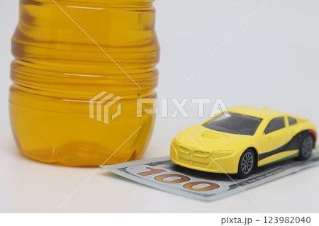 A bottle of vegetable oil and a typewriter lie on a banknote. Biodiesel, biofuel,  123982040