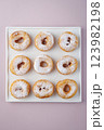 Donuts with powdered sugar on a light plate and a delicate purple background. Top view 123982198