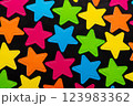 A vibrant assortment of multicolored star shapes in pink, blue, green, yellow, and orange, scattered on a black background 123983362