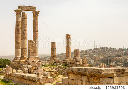 Roman ruined columns and many residential houses densily scattered on the hills in the downtown of Amman city, Kingdom of Jordan 123983798