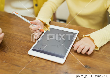 タブレット学習をする孫を見守る祖父母 123984244