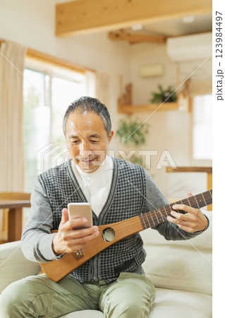 家で楽器を弾くシニア男性 123984497