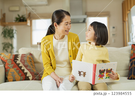 祖母と絵本を読む孫 123984555