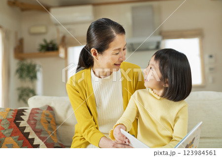 祖母と絵本を読む孫 123984561