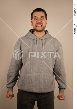 His expression conveys strong frustration and fury. The image captures the power of his emotional outburst. A close-up of a man's face in intense anger, his mouth wide open, showing raw emotion. 123985563