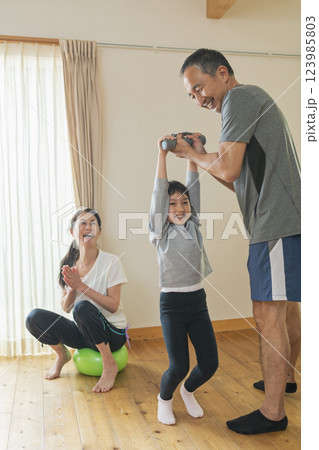 自宅で運動する祖父母と孫 自宅で運動する祖父母と孫 123985803